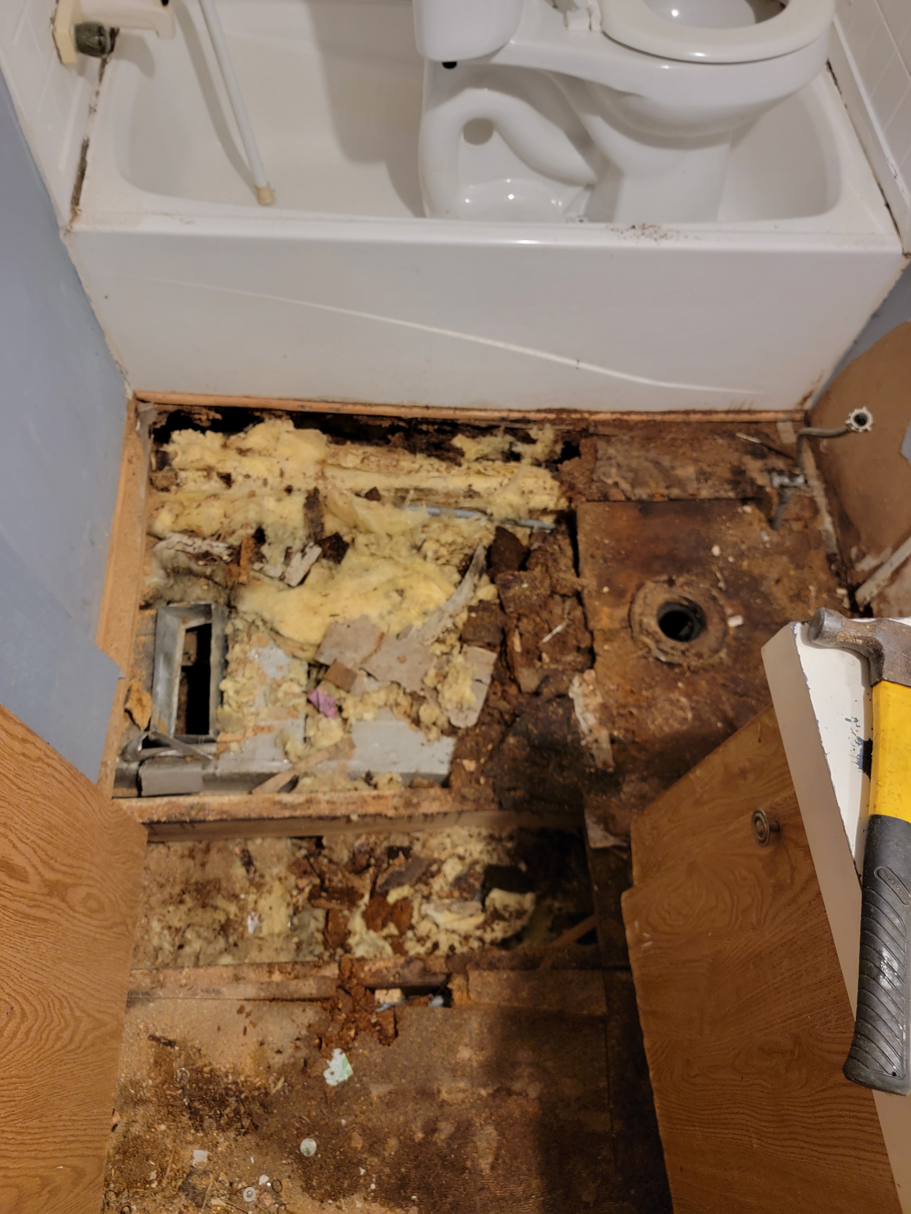 Damaged bathroom subfloor before repair