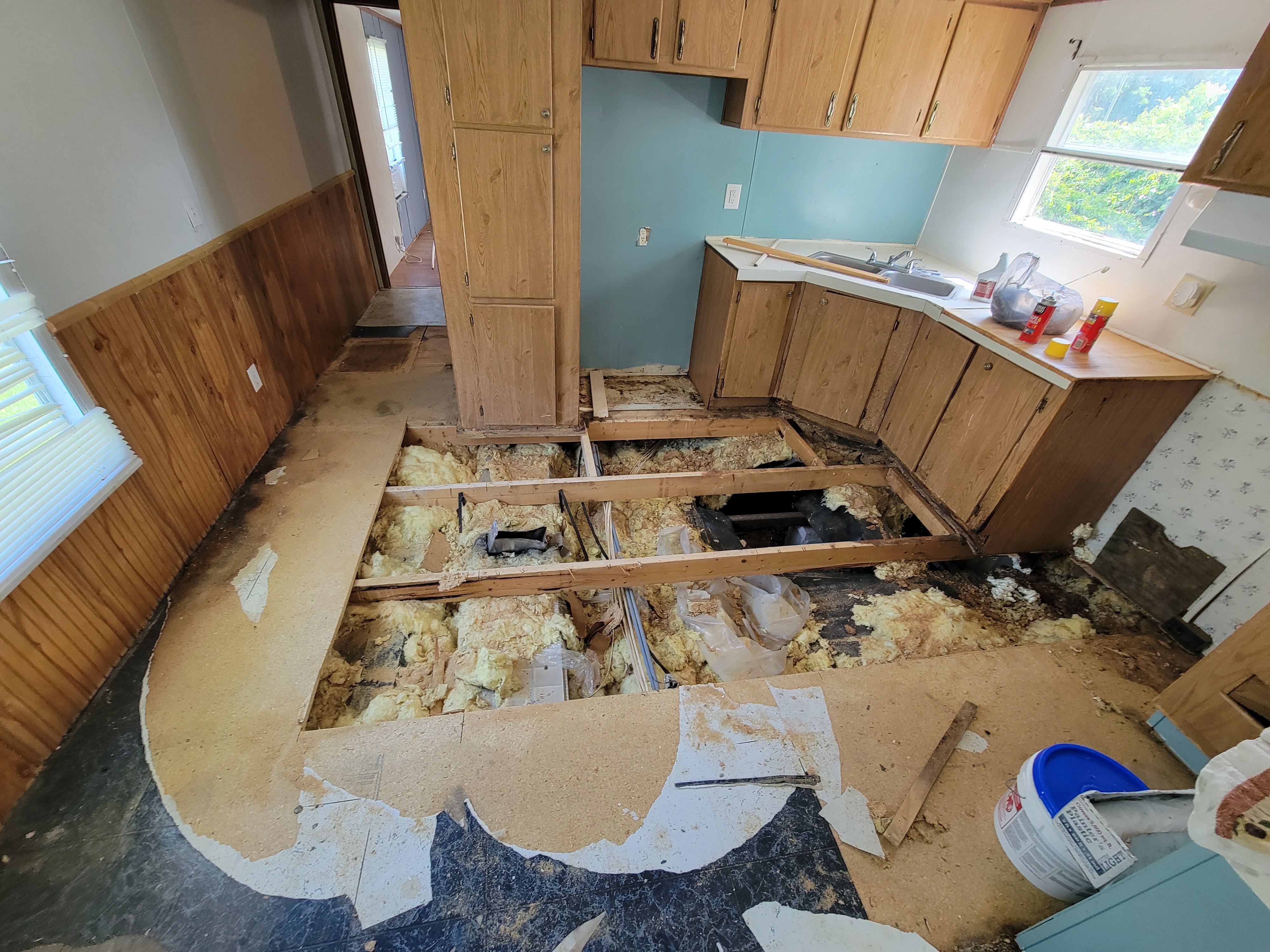 Kitchen with damaged subfloor before restoration