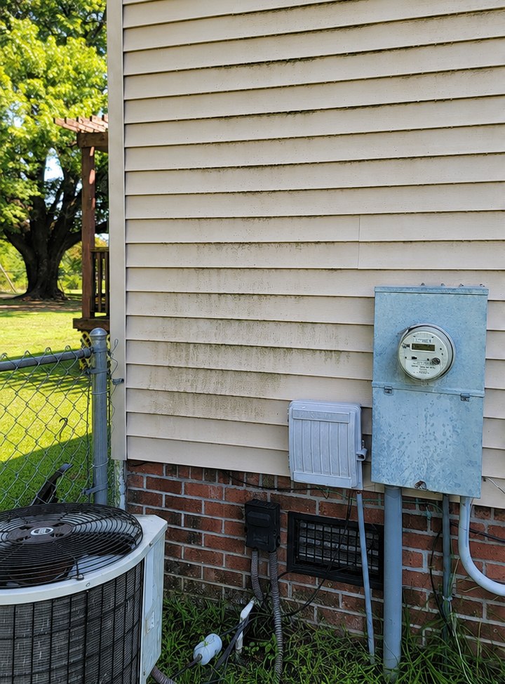 Exterior siding covered in green mildew and dirt streaks before washing